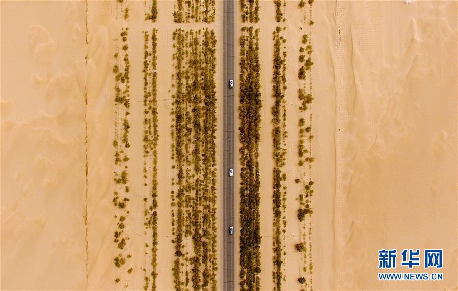 (壯闊東方潮奮進(jìn)新時(shí)代——慶祝改革開放40年)(1)公路在“死亡之海”里延伸